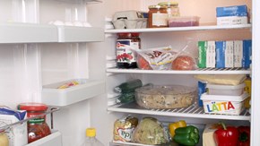 Ett öppet kylskåp med olika slags livsmedel inuti.